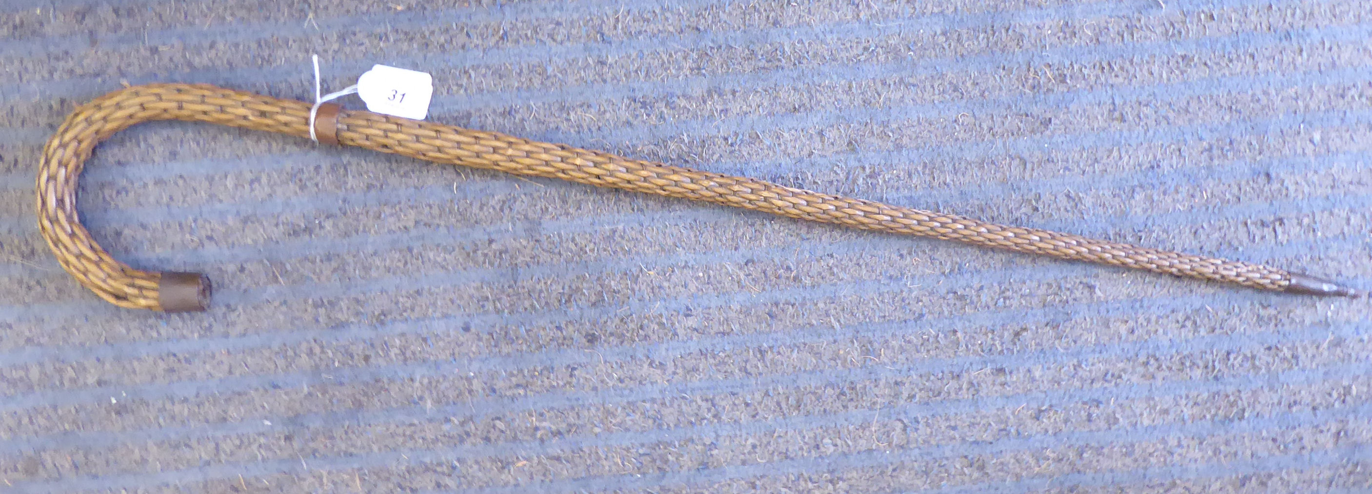 A late 19th/early 20thC copper wire bound and woven cane walking stick with a metal tip ferrule and