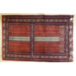 A Persian rug with stylised designs on a red ground 36'' x 57'' BSR