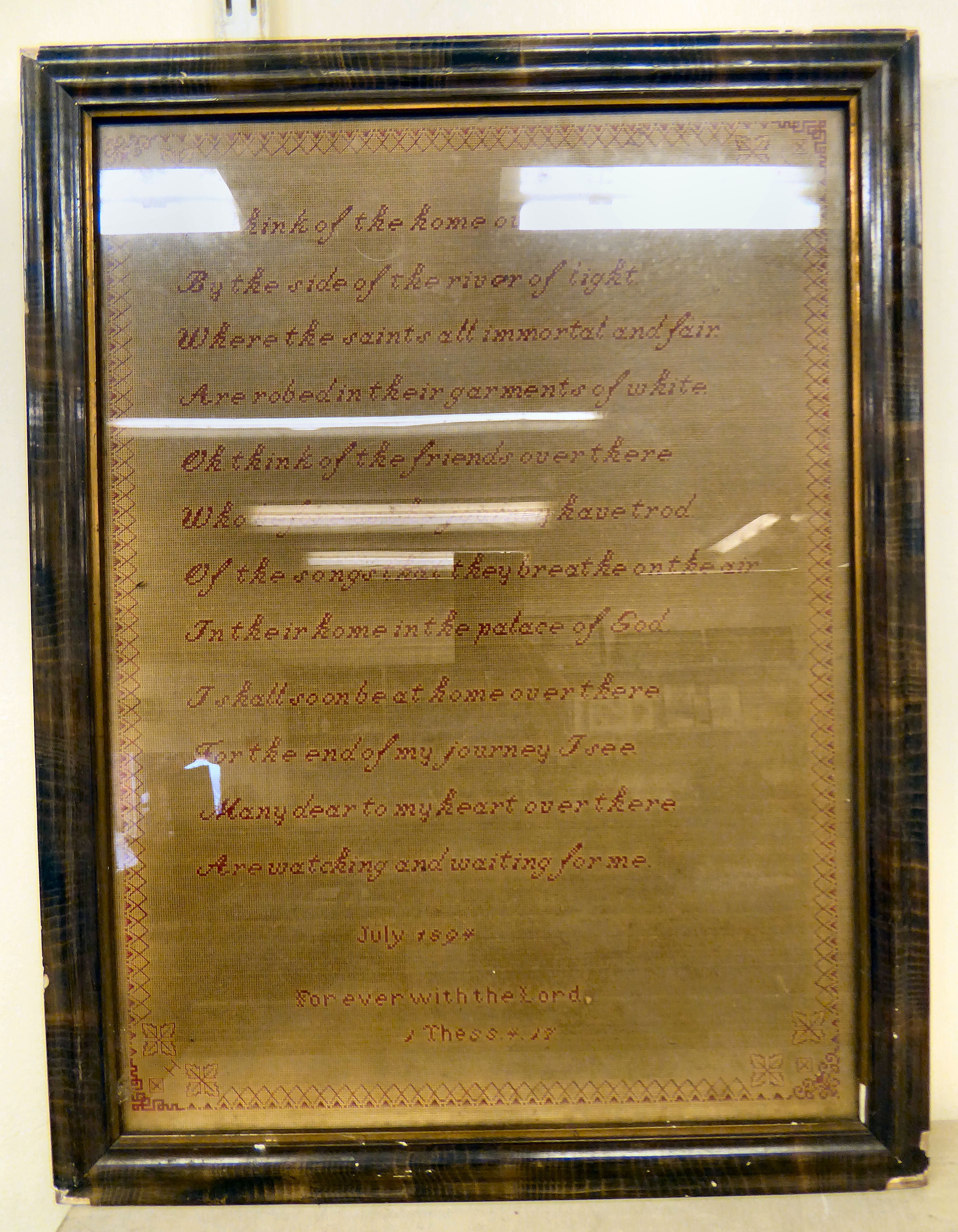 A late Victorian needlework, comprising twelve lines of verse,