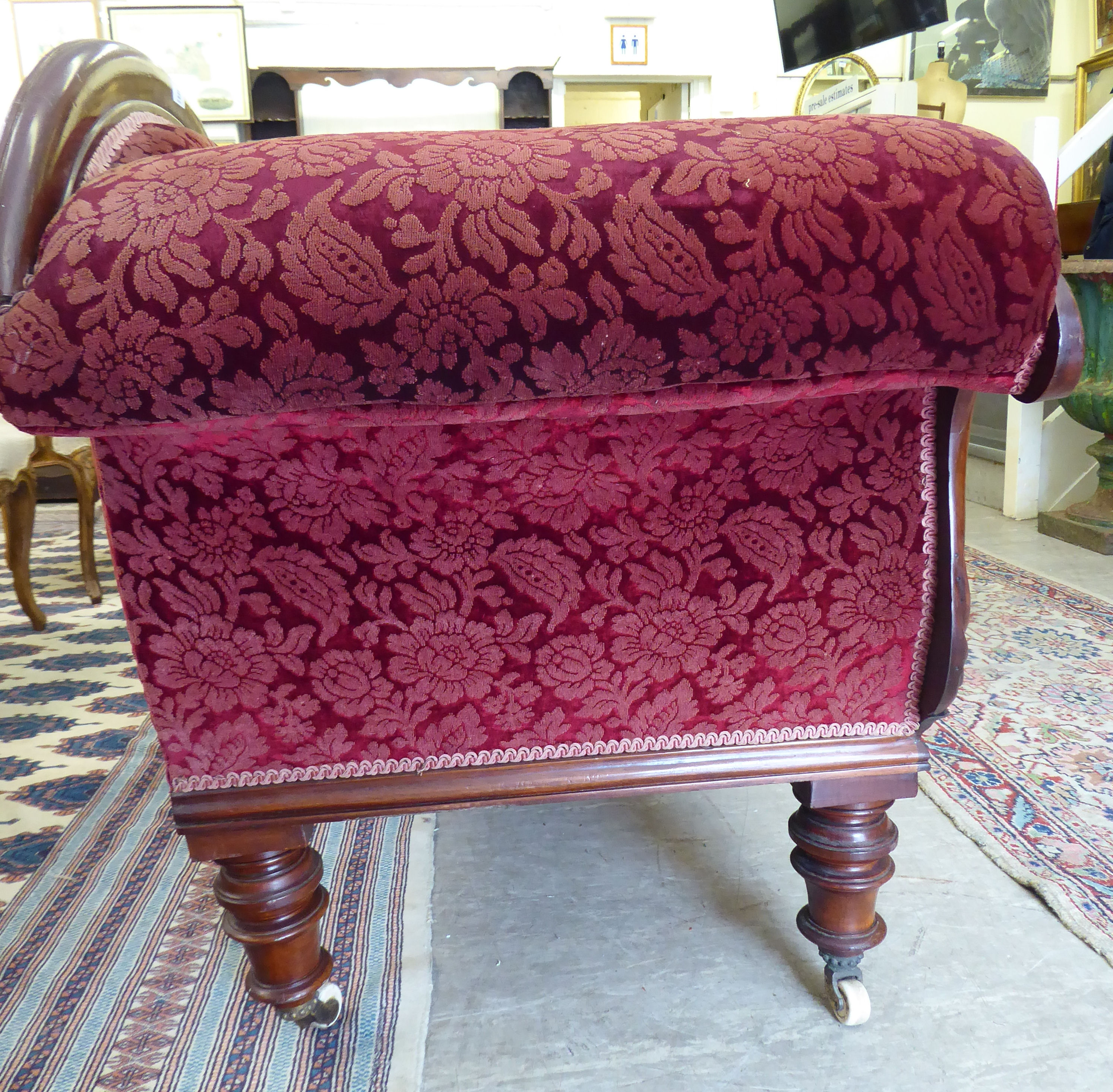 A late Victorian mahogany framed chaise longue, upholstered in a maroon floral fabric, - Image 4 of 4