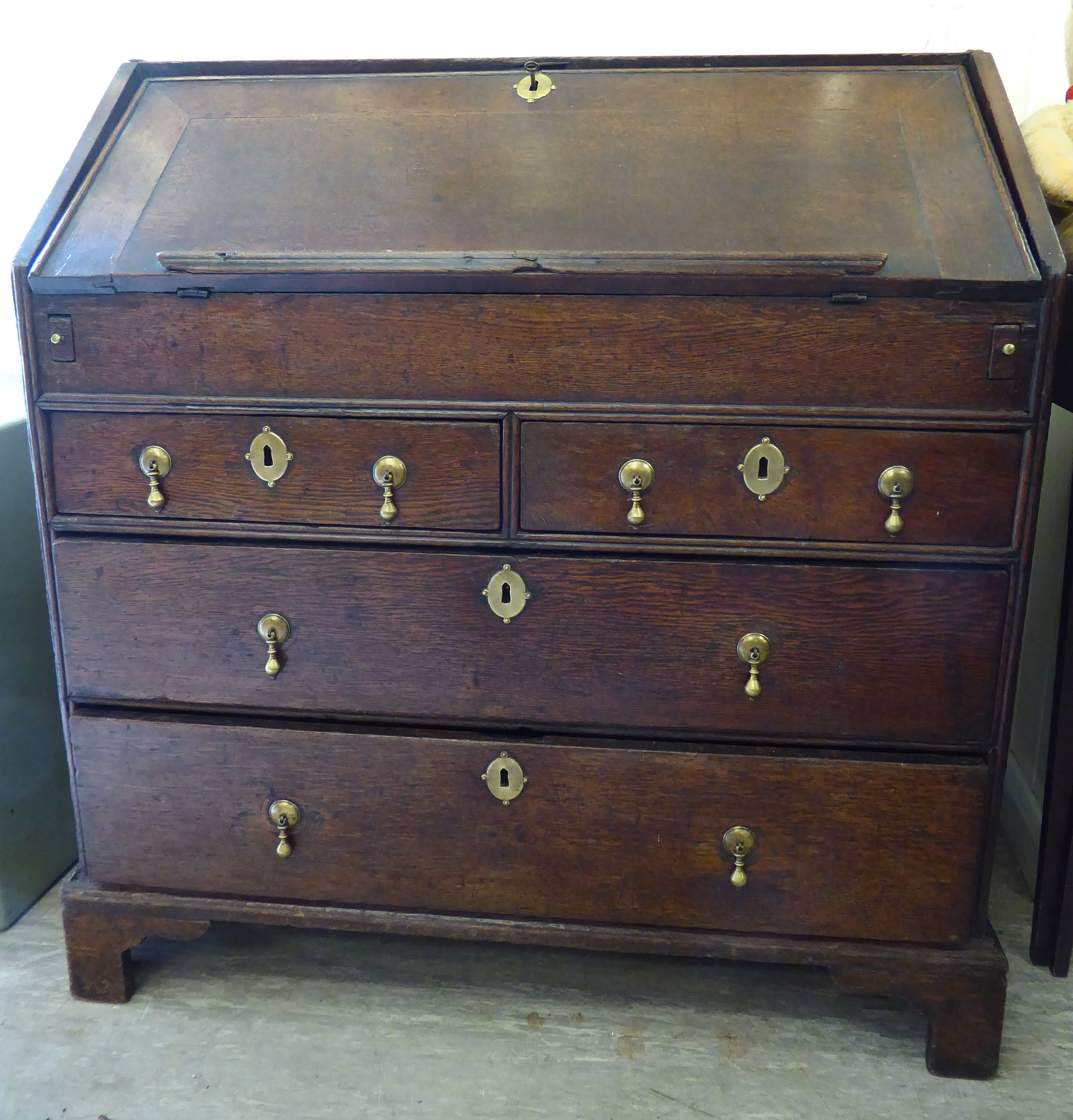 A George III oak bureau with a fall-flap, over two short/two long drawers,