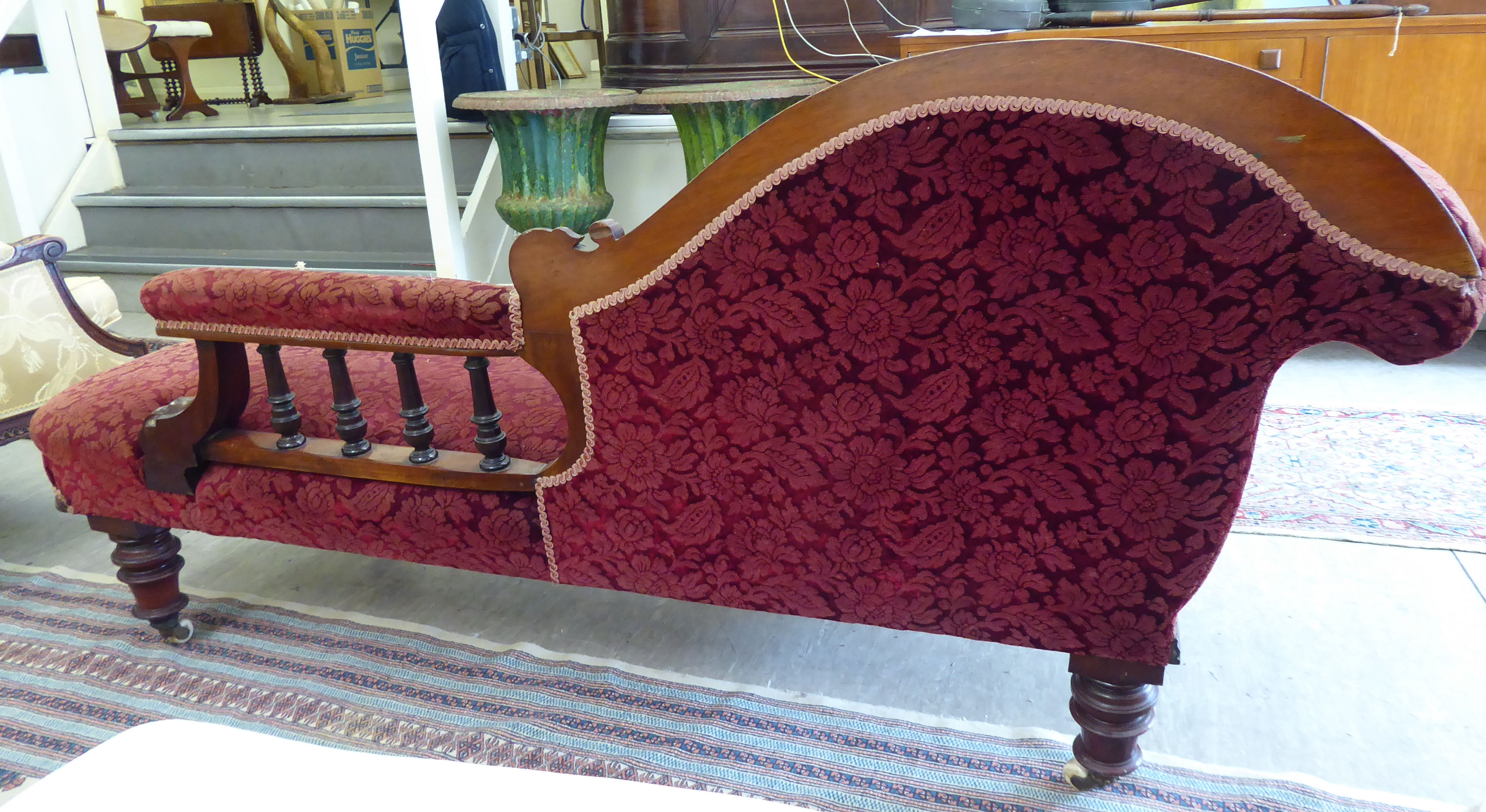 A late Victorian mahogany framed chaise longue, upholstered in a maroon floral fabric, - Image 2 of 4