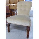 A 1920s oak framed nursing chair, the part-button upholstered back and seat raised on tapered,