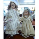 Two wax head dolls: to include a late 19thC example with fixed eyes,