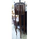 A 1920s stained oak jardiniere stand, raised on square supports,