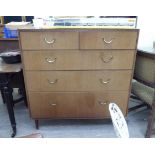 A mid 20thC teak finished five drawer dressing chest,