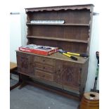 An early 20thC limed oak dresser, the shelved, planked back superstructure on a three drawer base,