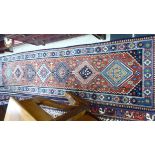 A Persian design runner with a central gul on a blue ground 122'' x 33'' CA