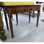 A mid Victorian mahogany side table with two in-line frieze drawers, raised on ring turned,
