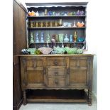 A mid 20thC cottage style oak dresser, the planked back and shelved superstructure,