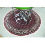 A Persian design rug with floral motifs on a red ground 62''dia CA