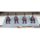 A cast iron novelty coat rack, fashioned as four dogs' tails,