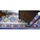 A Persian design runner with a central gul on a blue ground 122'' x 33'' LAB