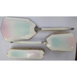 A matched three piece silver and enamel backed dressing table set,