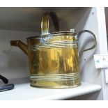 A 19thC maid's brass watering can of traditional form with two hinged lids OS1