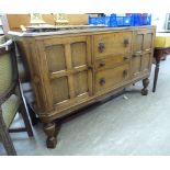 A 1930s Waring & Gillows stained oak sideboard with three central graduated drawers,
