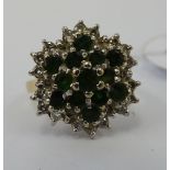 An 18ct gold emerald and diamond set cluster ring 11
