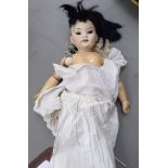 An early 20thC bisque head doll with painted features,
