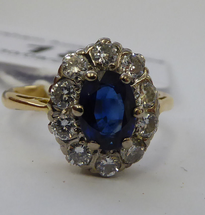 An 18ct gold cluster ring with a central sapphire,