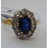 An 18ct gold cluster ring with a central sapphire,
