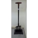 A modern cast iron boot scraper with a wooden handle,