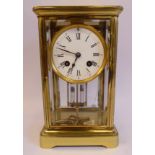 An early 20thC lacquered brass cased, four glass mantel clock,