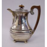 A silver hot water pot, of oval, bulbous, waisted form with gadrooned ornament, a swept spout,
