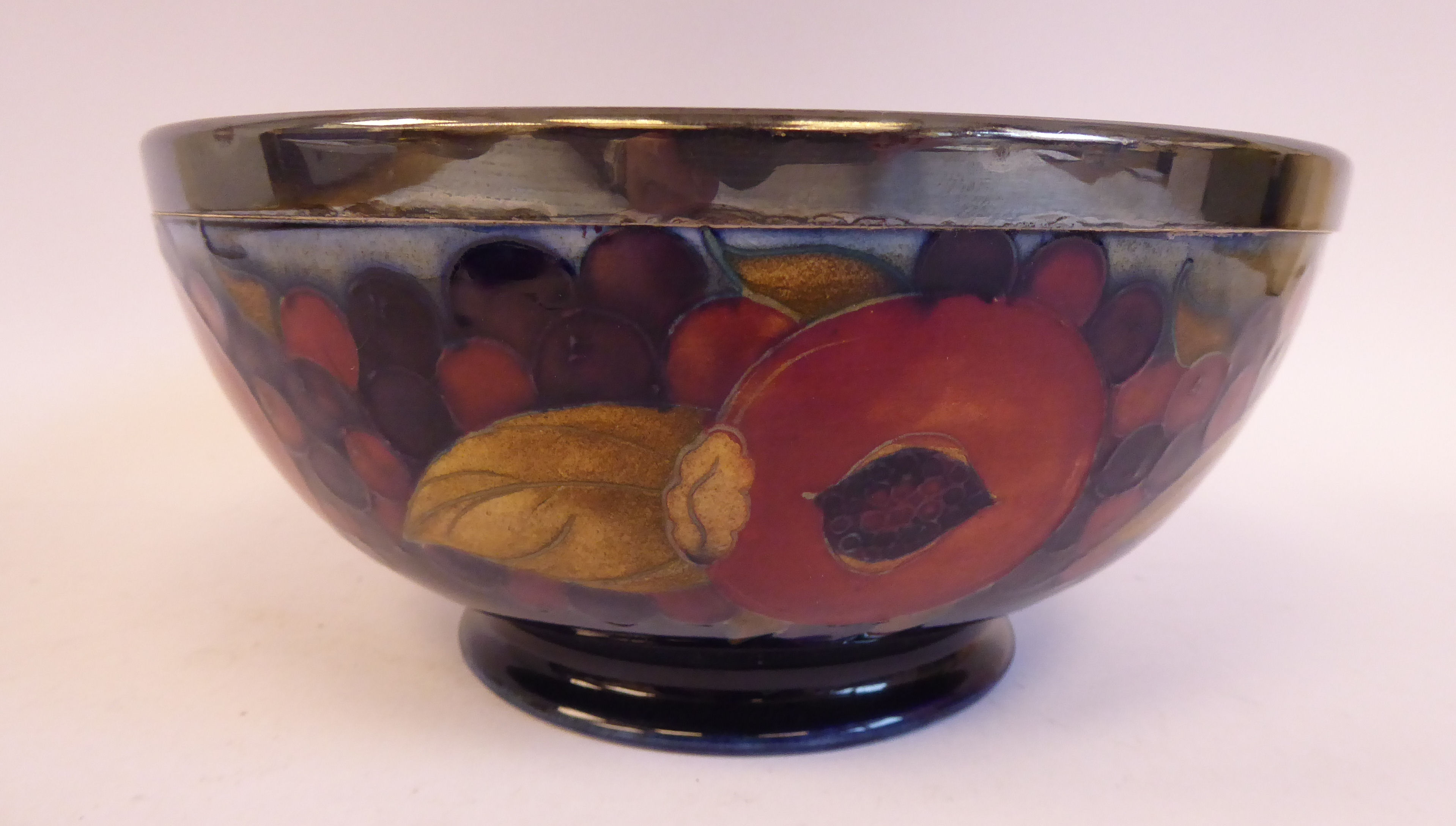 A Moorcroft pottery footed fruit bowl, decorated in a version of the Pomegranate design,