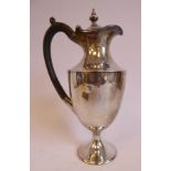 A late Victorian silver hot water jug of shouldered ovoid form with a wide, waisted neck,