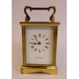 A mid 20thC lacquered brass cased carriage timepiece with reeded uprights,