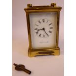 An early/mid 20thC lacquered brass cased carriage clock with bevelled glass panels and a folding