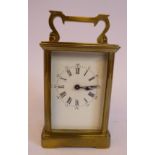 A mid 20thC lacquered brass cased carriage timepiece with bevelled glass panels and a folding top