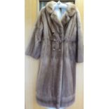 A knee-length blonde mink coat with a belt back,