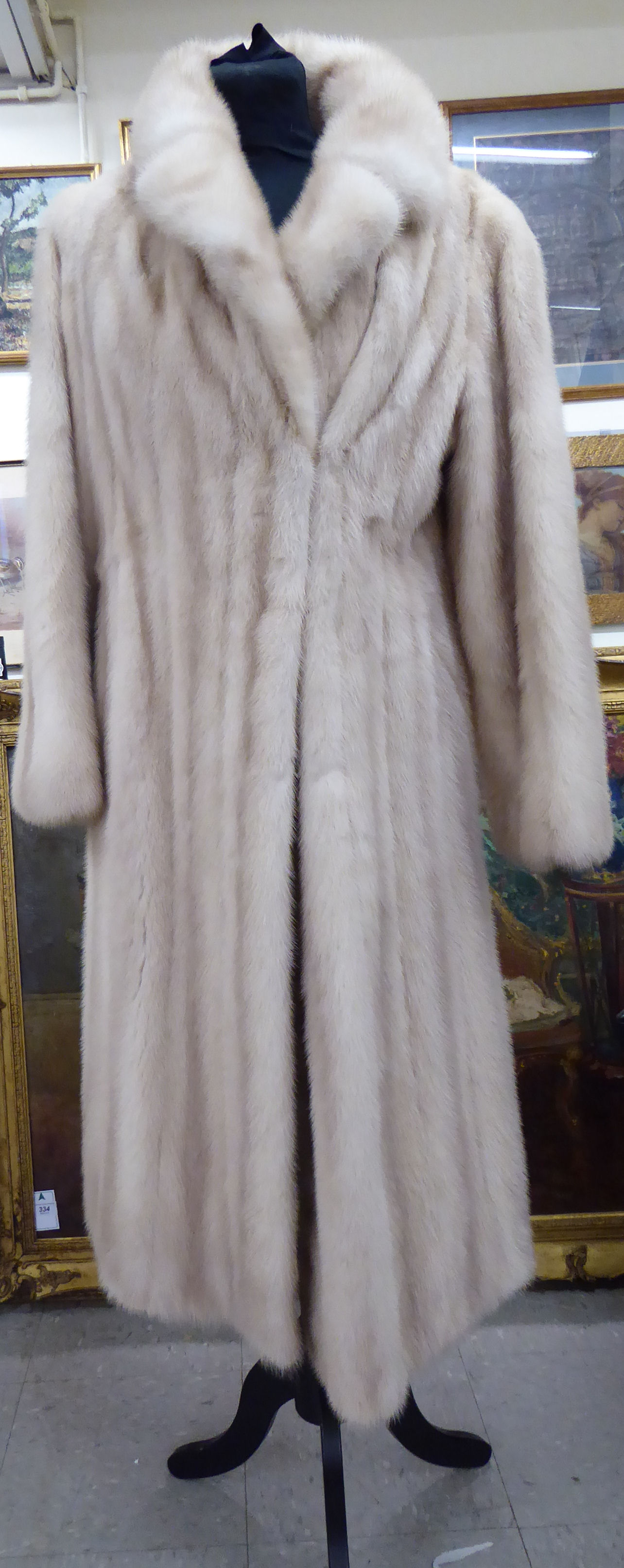 A pale blonde mink coat with a lapelled collar and satin lining bears the label of Siberian Fur