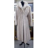 A pale blonde mink coat with a lapelled collar and satin lining bears the label of Siberian Fur