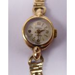 A lady's Regency 9ct gold oval cased wristwatch, on an open tablet link bracelet,