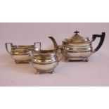 A three piece silver tea set of oval, ogee, banded form comprising a teapot with an S-shaped spout,