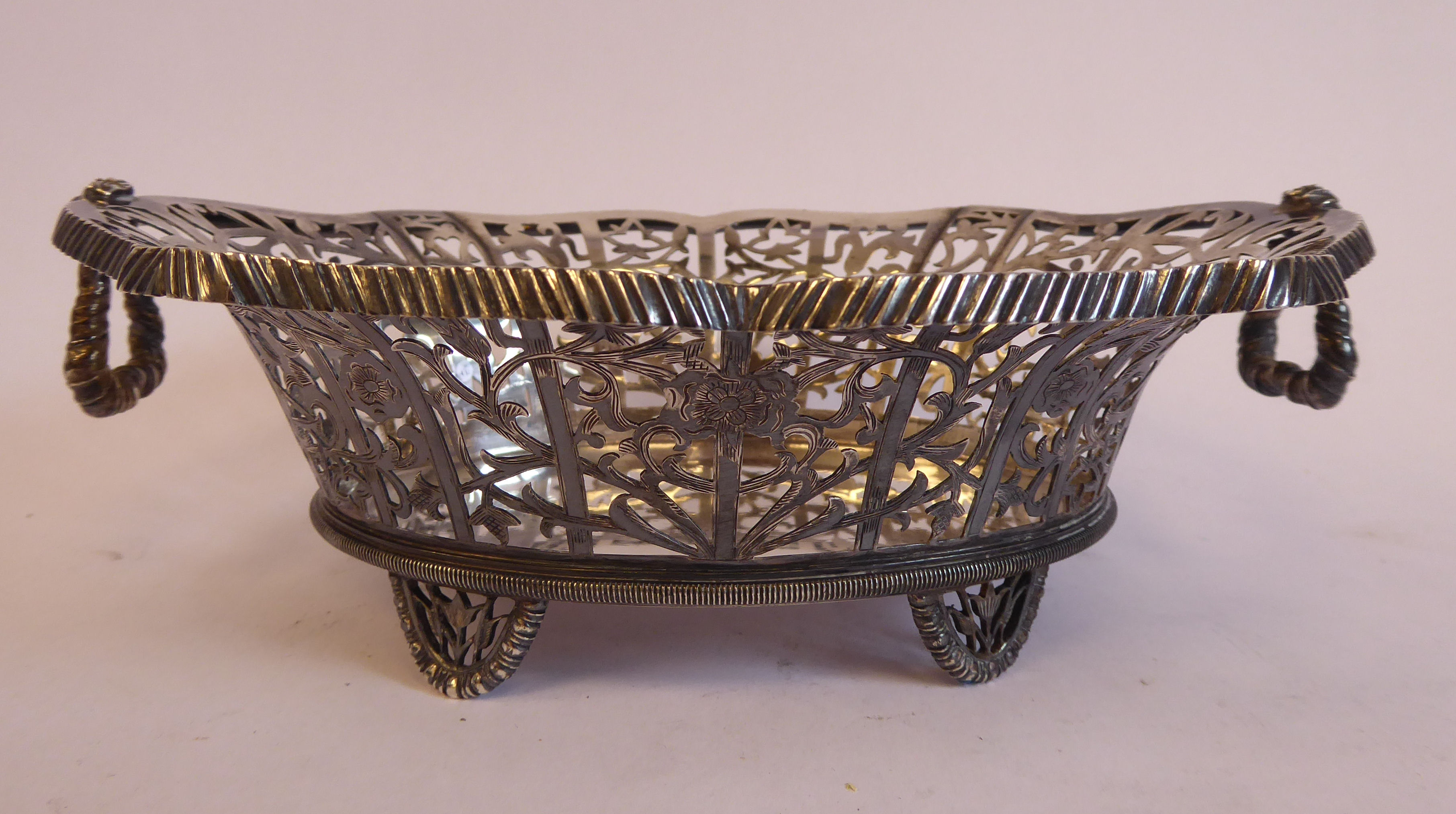 A late 19th/early 20thC Thai silver coloured metal oval basket with decoratively pierced, engraved,