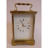 A mid 20thC lacquered brass cased carriage timepiece with bevelled glass panels and a folding top