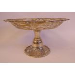 A silver cake dish with a level platter and a raised, wide, decoratively pierced,