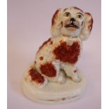 A mid 19thC Staffordshire pottery model, a seated King Charles Spaniel with painted features,