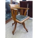 A 1920s ebony and boxwood inlaid light oak framed desk chair, the horseshoe shaped back,