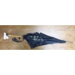 An Edwardian parasol with a black silk canopy, a bamboo shaft,