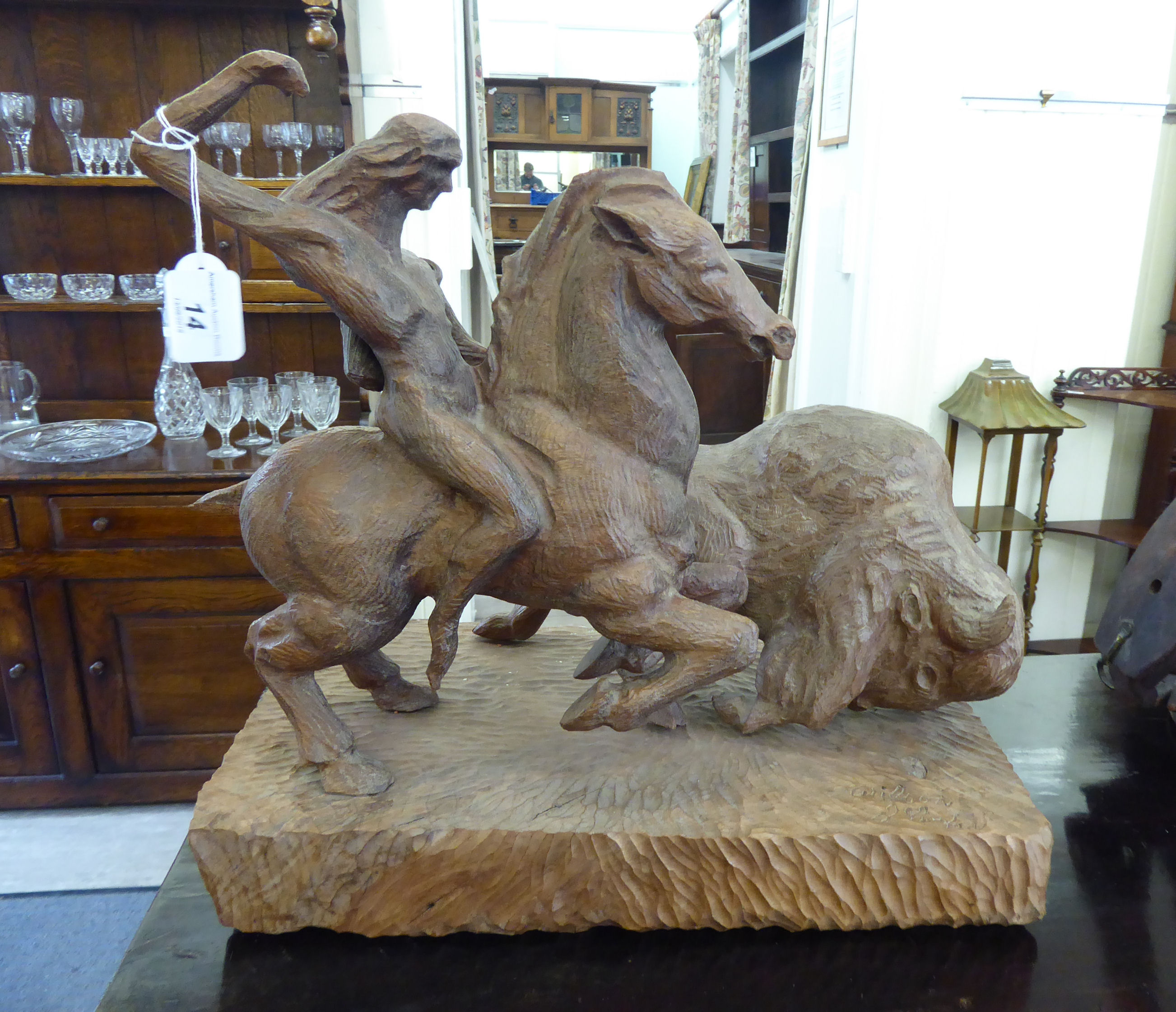 An early 20thC carved wooden sculpture, a Red Indian horseman chasing a bison,