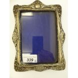 A silver photograph frame with double C-scroll ornament and a fabric covered back Birmingham 1905