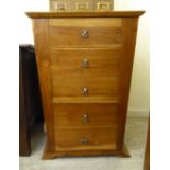 A modern honey coloured hardwood chest, comprising five tapered drawers,