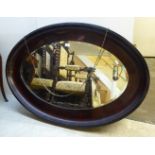 A 1920s mahogany framed oval wall mirror 31'' x 46'' BSR