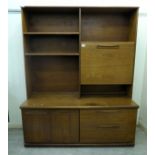 A 1970s teak two-section living room unit with an arrangement of open shelves and a fall flap,