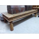 A modern Asian rustically constructed hardwood coffee table with a rivetted planked top,