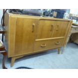A mid 20thC light oak sideboard with three doors, over a single drawer,